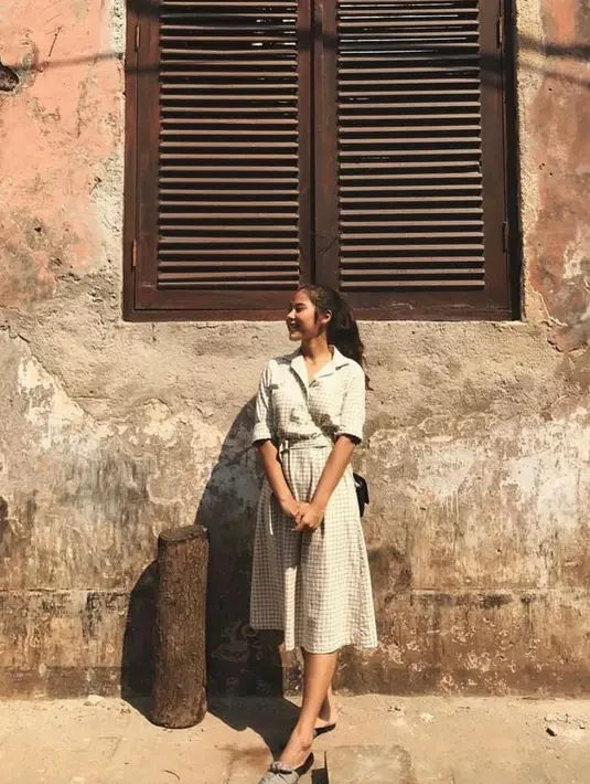 Dress vintage motif plaid cocok jadi outfit hangout. Ditambah loafers warna gelap dan tas hitam yang bikin OOTD  Nadin tambag keren.  (Instagram/cakecaine).