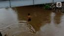 Seorang anak nekat melompat dari jembatan ke Kali Ciliwung Kalibata, Jakarta, Selasa (25/2/2020). Kali Ciliwung meluap usai hujan deras mengguyur Jakarta dan sekitarnya pada kemarin malam. (merdeka.com/magang/Muhammad Fayyadh)
