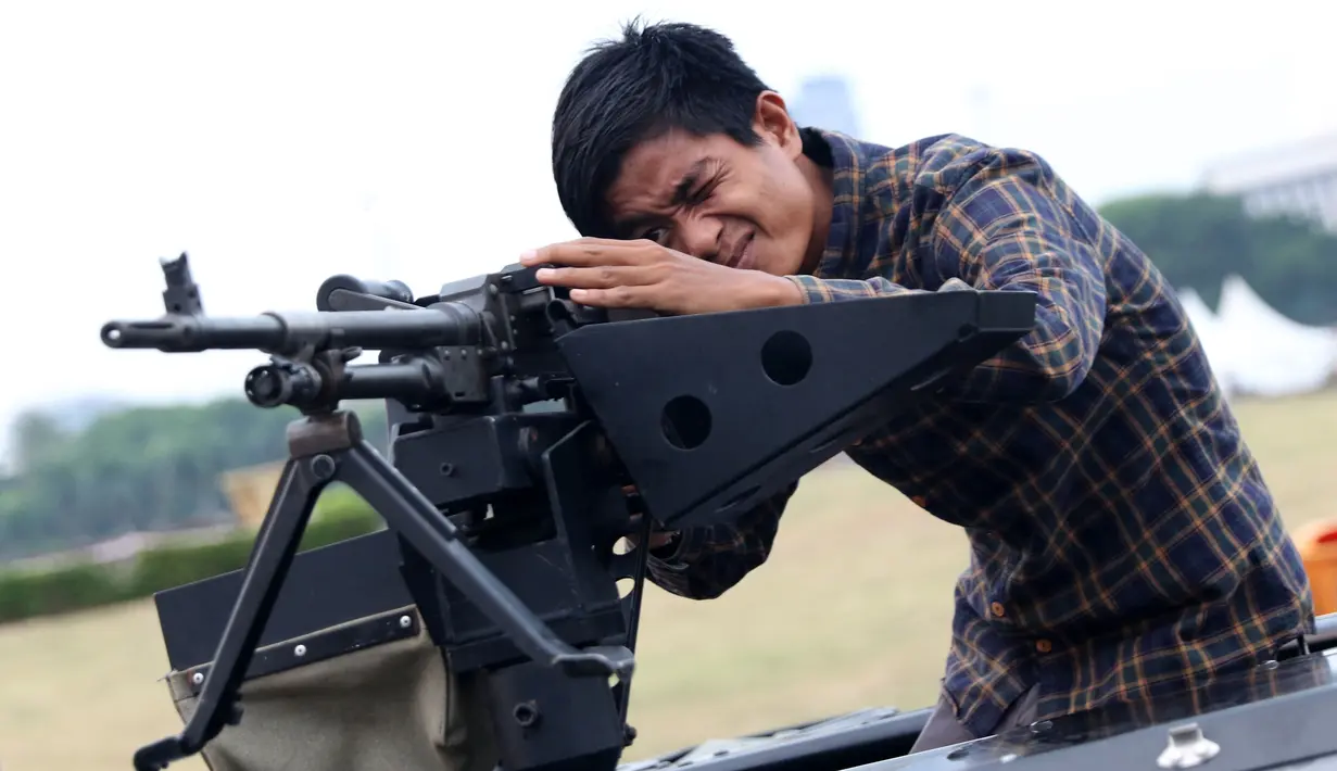 Warga bergaya dengan senjata TNI pada pameran Alat Utama Sistem Persenjataan TNI di Kawasan Monas, Jakarta, Kamis (27/9). Pameran ini berlangsung hingga 29 September. (Liputan6.com/Helmi Fithriansyah)