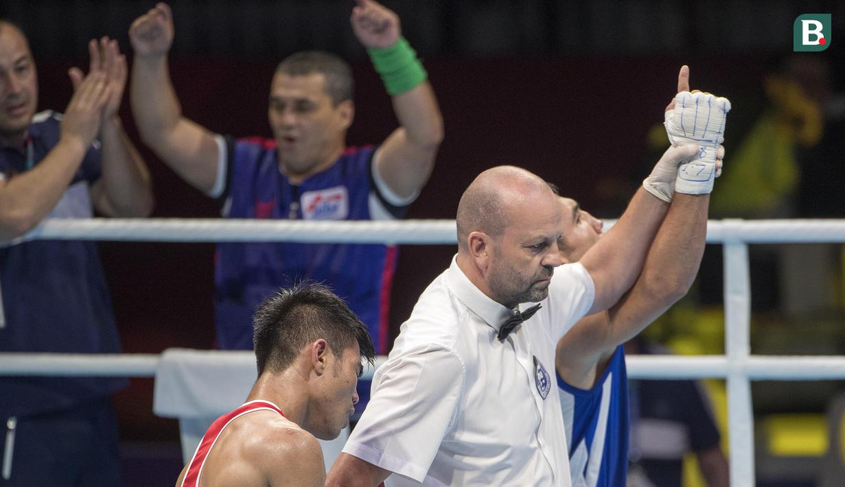Ekpresi kecewa petinju asal Indonesia Sunan Agung Amoragam setelah dikalahkan oleh Mirazizbek Mirzakhalilov asal Uzbekistan di babak semifinal kelas bantam (56 kg) Asian Games 2018 di JIExpo Kemayoran Jakarta pada Jumat (31/8/2018). (Bola.com/Peksi Cahyo)