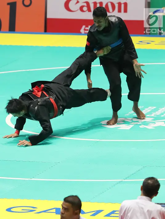 Pesilat Timor Leste, David No-Ano Ximenes (atas) bertanding melawan pesilat Indonesia, Komang Harik Adiputra dalam kelas 65-70 kg Putra Asian Games 2018 di Padepokan Pencak Silat TMII, Jakarta, Kamis (23/8). Komang unggul 5-0. (Liputan6.com/Fery Pradolo)