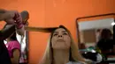 Seorang narapidana melakukan persiapan untuk  berkompetisi dalam kontes kecantikan Miss Talavera Bruce 2018 di Rio de Janeiro, Brasil, Selasa (4/12). Kontes ini digelar di penjara khusus perempuan dengan keamanan maksimum. (AP/Silvia Izquierdo)