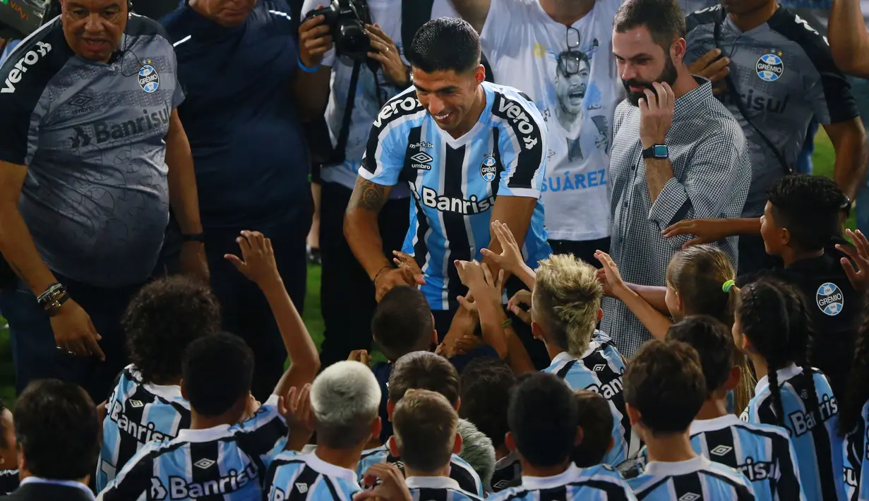 Striker Uruguay Luis Suarez menyapa para penggemar saat sesi perkenalannya sebagai pemain baru Gremio di stadion Gremio Arena, di Porto Alegre, Brasil, Rabu (4/1/2023). Luis Suarez resmi berlabuh di Brasil bersama Gremio. (Silvio AVILA / AFP)