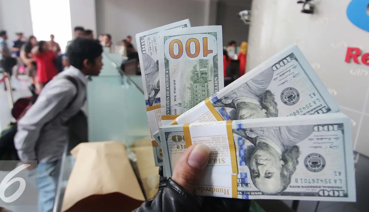 Pengunjung memperlihatkan uang pecahan US$100 di Jakarta, Jumat (9/10/2015). Nilai tukar rupiah terhadap dolar AS pada perdagangan akhir pekan ini, Jumat (9/10/2015) mengalami penguatan, bahkan bergerak ke level Rp 13.400. (Liputan6.com/Angga Yuniar)