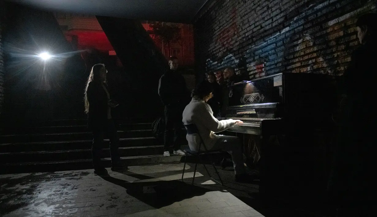 Seseorang memainkan piano di jalan bawah tanah saat pemadaman listrik di Kiev, Ukraina, 6 November 2022. Serangan Rusia terhadap kota-kota di Ukraina masih berlanjut. (AP Photo/Andrew Kravchenko)