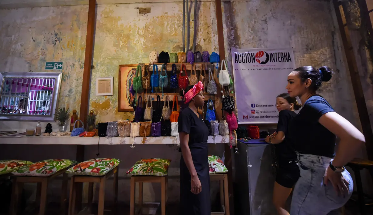 Narapidana wanita, Arleth Martinez berbicara dengan narapidana lain di restoran Interno di Cartagena, Kolombia (24/8). Interno adalah restoran pertama di negara Kolombia yang beroperasi di dalam penjara wanita. (AFP Photo/Raul Arboleda)