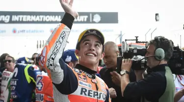 Pebalap tim MotoGP Repsol Honda Marc Marquez tersenyum saat menyapa fans setelah kualifikasi MotoGP Thailand 2018 di Sirkuit Internasional Buriram (6/10). Marquez menorehkan waktu tercepat dengan catatan waktu 1.30.088. (AFP Photo/Lillian Suwanrmpha)