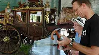 Dua wisman mengamati Kereta Kyai Garudayaksa yang ditarik delapan kuda yang dibuat Hermans&amp;co, Den Haag, Belanda tahun 1867-1869 di Ruang Pegelaran Kraton Yogyakarta. (ANTARA)