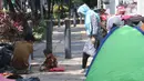 Pencari suaka beraktivitas di trotoar kantor UNHCR, Jalan Kebon Sirih, Jakarta, Sabtu (1/5/2021). Para pencari suaka itu menuntut Komisi Tinggi PBB untuk Pengungsi (UNHCR) meminta kejelasan atas status dan memperhatikan nasib mereka selama hidup di Indonesia. (Liputan6.com/Herman Zakharia)