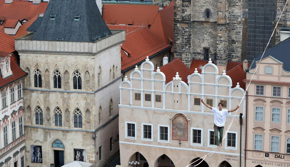 Atlet menyeimbangkan tubuhnya saat berjalan di atas tali yang membentang di Old Town Square, Praha, Republik Ceko, (25/9). Pertunjukan tersebut merupakan bagian kampanye dukungan orang-orang yang hidup dengan diabetes. (AP Photo/Petr David Josek)