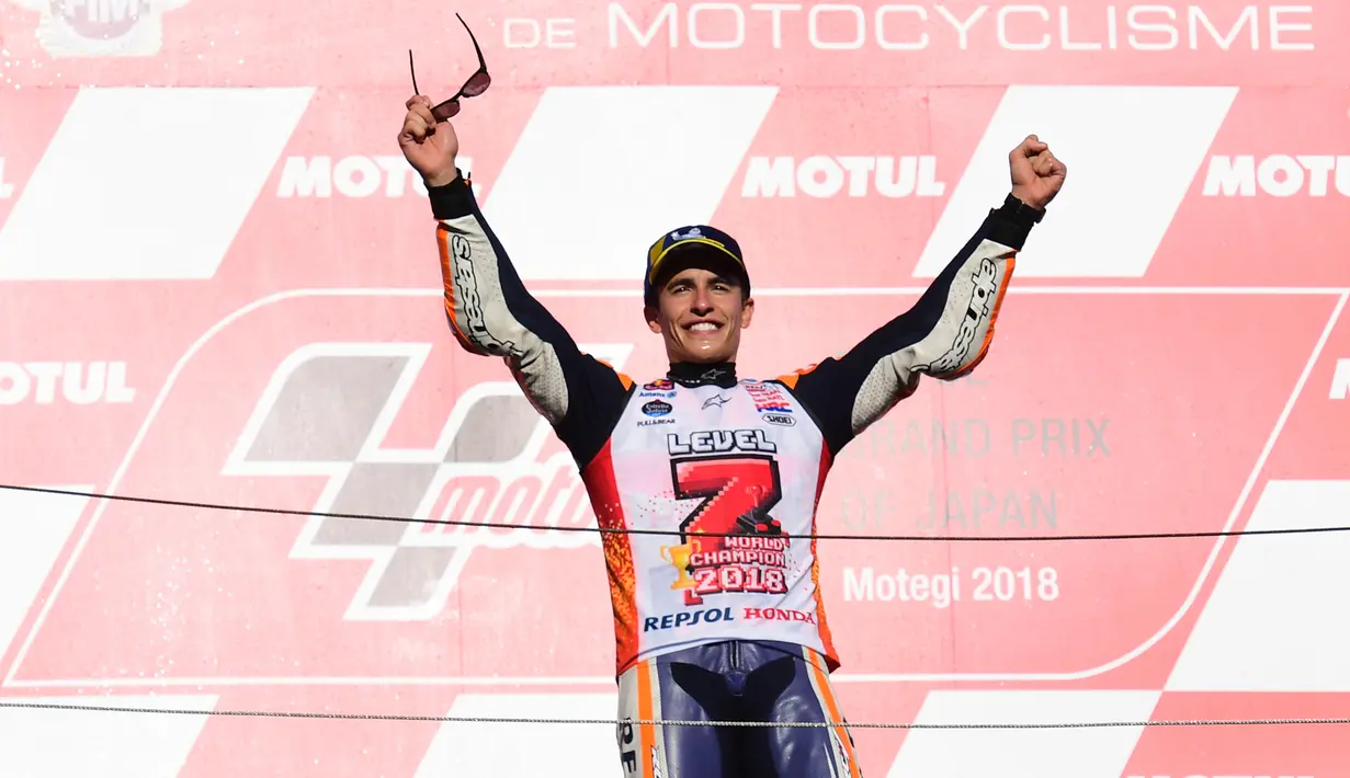 Pembalap Repsol Honda, Marc Marquez berselebrasi di atas podium setelah memenangi balapan MotoGP Jepang 2018 di Twin Ring Motegi, Minggu (21/10). Kemenangan Marquez di Jepang sekaligus membuatnya menjadi juara dunia MotoGP 2018. (Martin BUREAU / AFP)