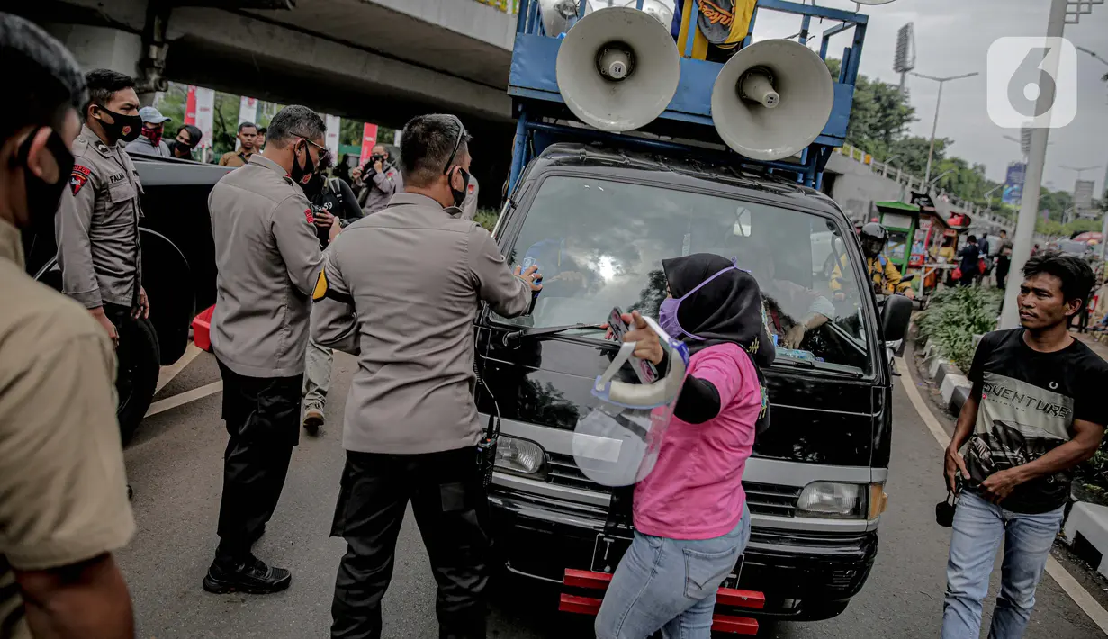 Petugas kepolisian yang berjaga memberhentikan mobil komando aksi di sekitar Gedung DPR, Jakarta, Jumat (14/8/2020). Polda Metro Jaya melarang adanya unjuk rasa di depan Gedung DPR/MPR yang bertepatan dengan sidang tahunan sekaligus pidato kenegaraan Presiden Jokowi. (Liputan6.com/Faizal Fanani)