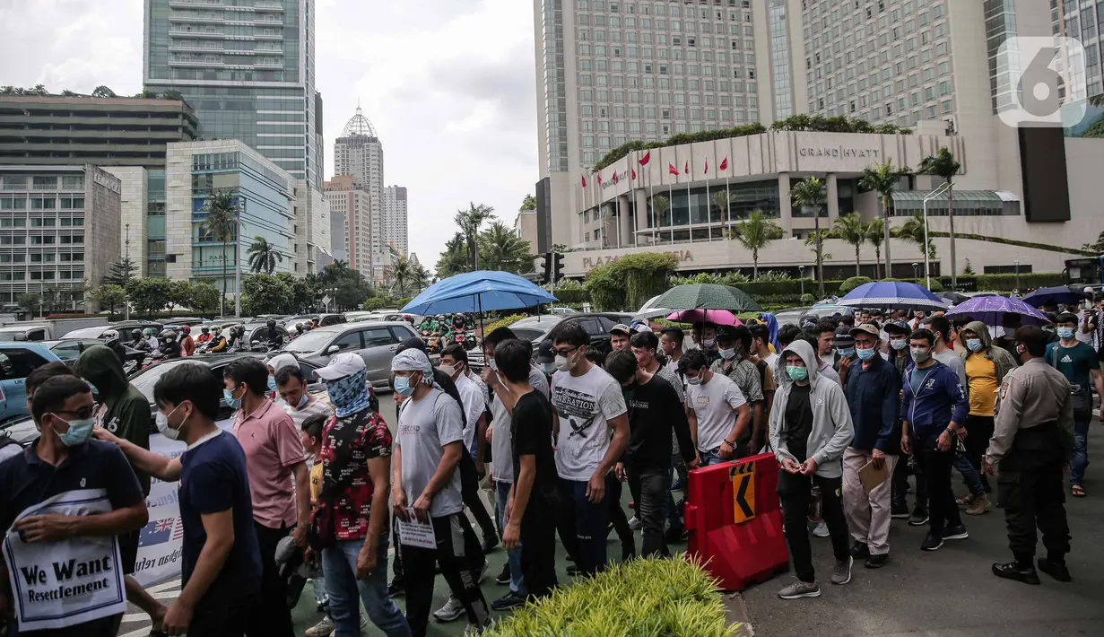 Ratusan imigran Afghanistan jalan kaki menuju Kedubes Kanada di Jakarta, Senin (13/12/2021). Dengan membawa spanduk dan poster, mereka menuntut UNHCR dan IOM segera memproses penempatan mereka ke negara tujuan seperti Kanada, Australia, Selandia Baru maupun AS. (Liputan6.com/Faizal Fanani)