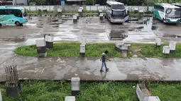 Seorang pria berjalan di Teminal Pondok Cabe, Jakarta, Senin (18/3). Aktivitas di Terminal Pondok Cabe pada Februari 2019 menunjukkan terdapat 646 Bus Angkutan Kota Antar Provinsi dengan 1171 keberangkatan penumpang. (Liputan6.com/Immanuel Antonius)