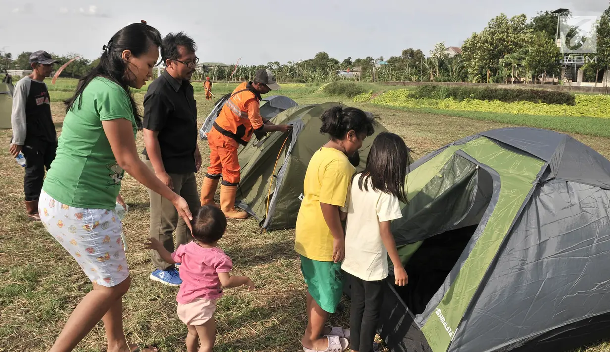 Anak-anak mencoba masuk ke dalam tenda saat persiapan untuk doa bersama pada malam Tahun Baru di Cipinang Melayu, Jakarta, Minggu (30/12). Warga Cipinang Melayu juga akan menyalakan 2.019 lilin pada malam Tahun Baru. (Merdeka.com/ Iqbal S. Nugroho)