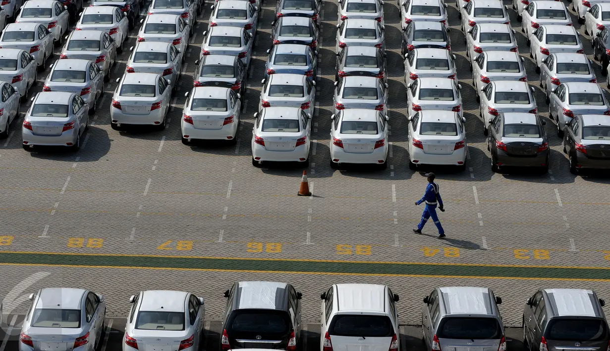 Petugas melintas diantara mobil yang baru diturunkan dari kapal pengangkut di Tanjung Priok Car, Terminal Pelabuhan Tanjung Priok, Jakarta, Rabu (29/7/2015). Pasar otomotif nasional menyusut 15,3% selama paruh pertama 2015. (Liputan6.com/Johan Tallo)