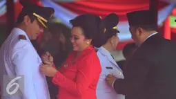 Walikota Semarang Hendar Prihadi saat dipasangkan lencana oleh Istrinya saat mengikuti pelantikan di Lapangan Simpanglima Semarang , Rabu (17/2). Sebanyak 17  pasangan kepala daerah dilantik untuk periode 2016-2021. (Liputan6.com/Gholib)