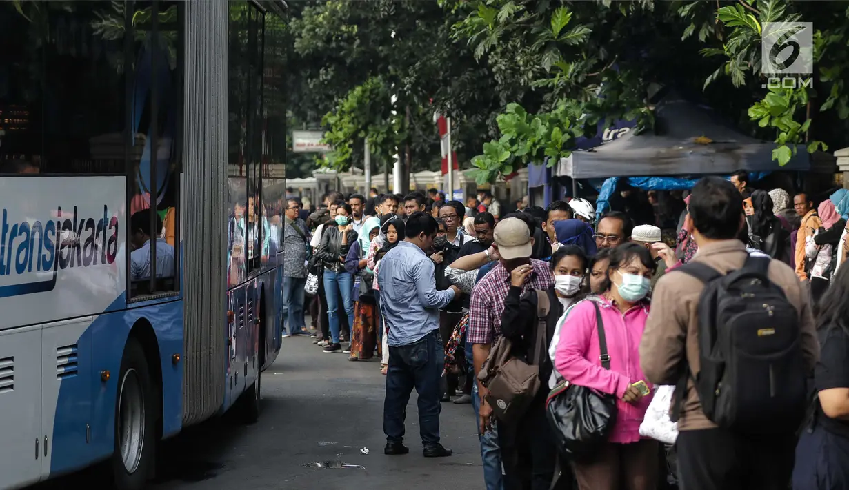Masyarakat mengantre untuk menaiki bus Transjakarta di depan Cibubur Junction, Jakarta, Senin (16/4). Imbas penerapan penerapan ganjil genap di ruas Gerbang Tol Cibubur 2 sebagaian masyarakat memilih menggunakan Transjakarta. (Liputan6.com/Faizal Fanani)