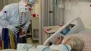 Badut medis menghibur seorang pasien COVID-19 di ruang perawatan Ziv Medical Center di Kota Safed, Israel utara, pada 19 November 2020. (Xinhua/JINI/Erez Ben Simon)