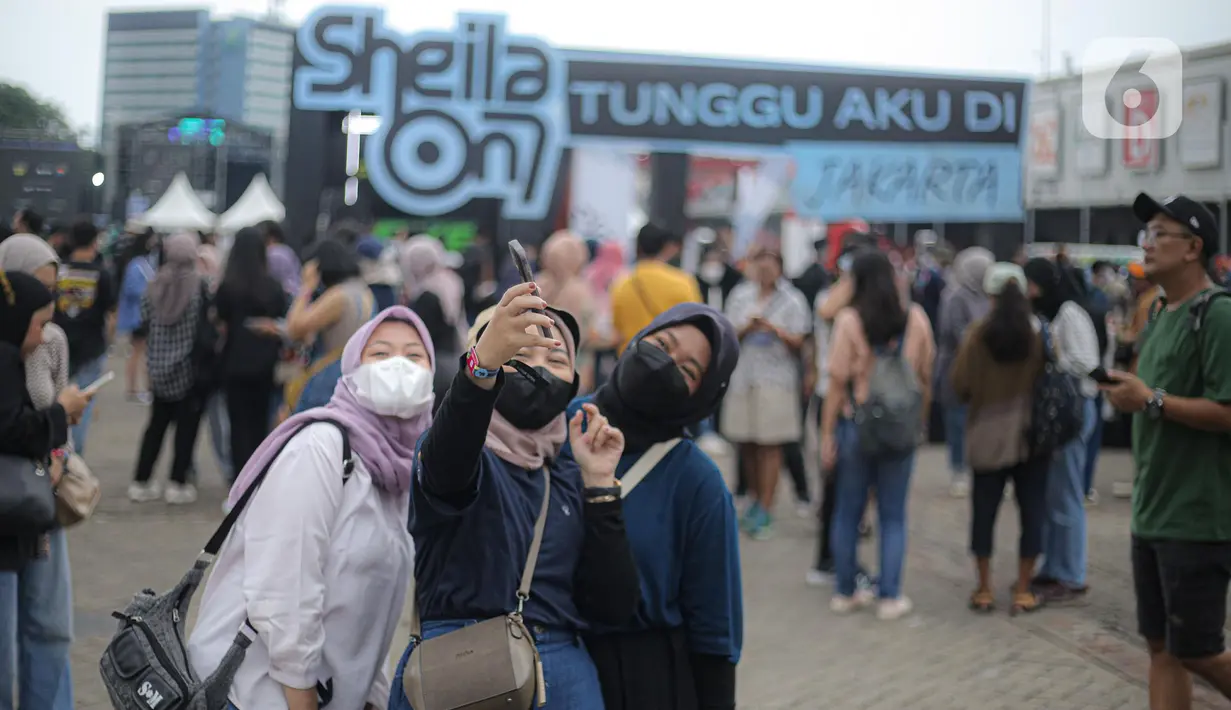 Penonton melakukan swafoto saat berlangsungnya konser Sheila On 7 yang bertajuk 'Tunggu Aku di Jakarta' di kawasan JIExpo Kemayoran, Jakarta Pusat, Sabtu, (28/1/2023). Jelang penampilan grup musik Sheila On 7 dalam konser bertajuk 'Tunggu Aku di Jakarta' penonton mulai memadati kawasan tersebut. (Liputan6.com/Faizal Fanani)