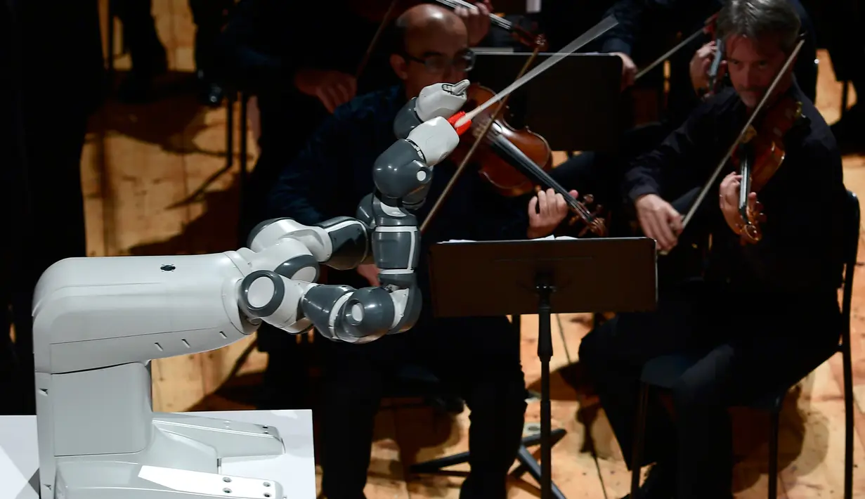 Robot Humanaid YuMi saat memimpin konser Lucca Philharmonic Orchestra di The Teatro Verdi di Pisa, Italia (12/9). Robot YuMi dirancang untuk minirukan isyarat Colombini. (AFP Photo/Miguel Medina)