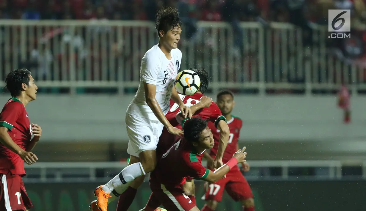 Pemain timnas Indonesia U-23 mencoba menghalangi pergerakan penyerang Korea Selatan U-23, Kim Jeung Ho pada laga persahabatan di Stadion Pakansari, Kab Bogor, Sabtu (23/6). Indonesia U-23 kalah 1-2. (Liputan6.com/Helmi Fithriansyah)