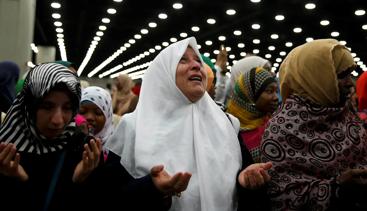 Nahed Ahmed Zeead dari Irak memanjatkan doa ketika menghadiri salat jenazah Muhammad Ali di Louisville, Kentucky, AS, Kamis (9/6). Ribuan orang hadir dalam salat jenazah almarhum legenda tinju dunia Muhammad Ali. (REUTERS/Lucy Nicholson)