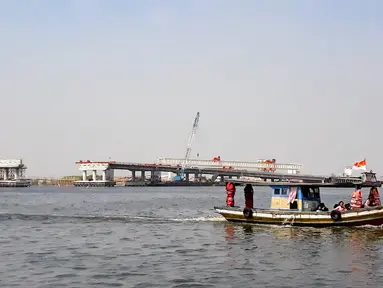 Kapal tradisional melintas dekat proyek pembangunan jembatan penghubung Dadap Tangerang-Pulau C di Kamal Muara, Penjaringan, Jakarta Utara, Minggu (17/11/2019). Jembatan tersebut nantinya akan menghubungkan wilayah Dadap di Tangerang dengan reklamasi Pulau C di Jakarta. (merdeka.com/Iqbal Nugroho)
