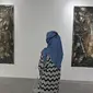 Pengunjung melihat karya yang dipajang dalam pameran Pulih di Pasar Seni, Ancol, Jakarta, Sabtu (14/11/20). Sambil menikmati karya seni, pengunjung juga diharapkan mematuhi protokol kesehatan dan kebersihan yang diterapkan pihak Pasar Seni Ancol. (Liputan6.com/Herman Zakharia)