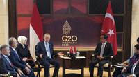 Presiden Joko Widodo berbincang dengan Presiden Turki Recep Tayyip Erdogan saat pertemuan bilateral jelang KTT G20 di Nusa Dua, Bali, Senin (14/11/2022). KTT G20 yang digelar pada 15-16 November di Bali memiliki tema utama 'Recover Together, Recover Stronger'. (Hendra A Setyawan/Pool Photo via AP)