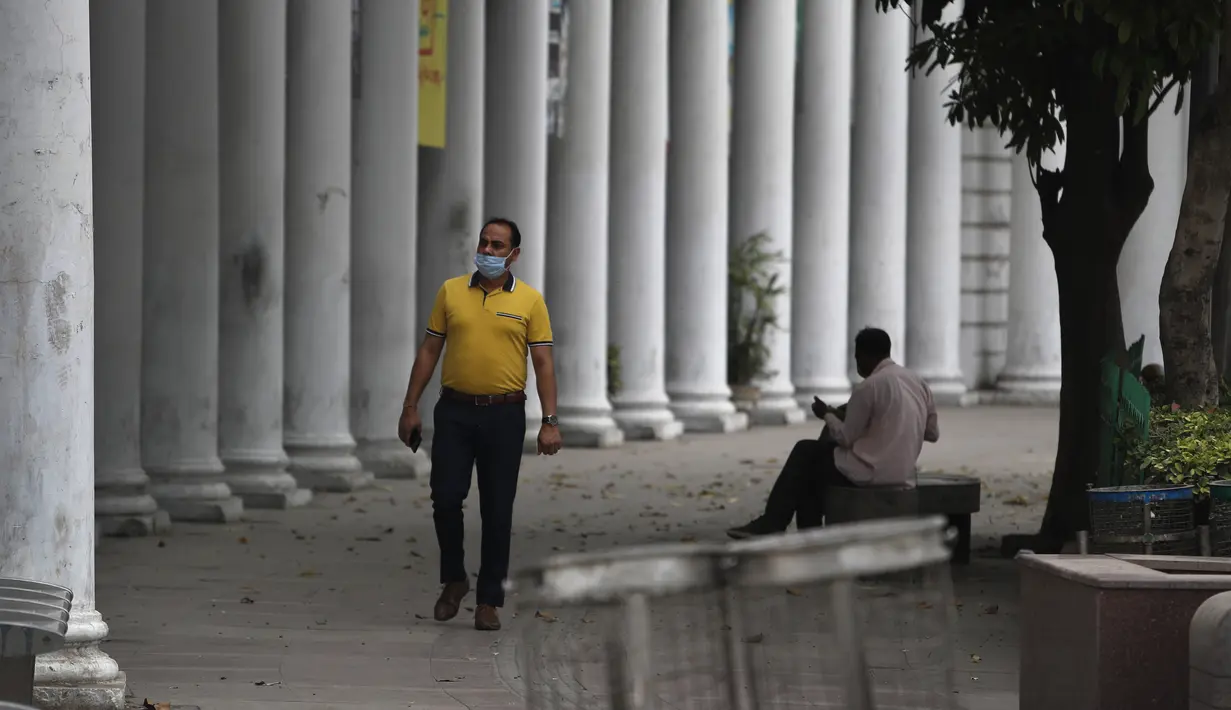 Seorang pria berjalan melewati pasar tertutup pada hari pertama lockdown diberlakukan di ibu kota India, New Delhi, Selasa (20/4/2021). India melaporkan 259.170 infeksi baru dan 1.761 kematian akibat Covid-19 dalam 24 jam terakhir. (AP Photo/Manish Swarup)