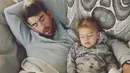 Nicole Phelps mengunggah foo suaminya, Michael Phelps saat tertidur lelap di sofa bersama dengan anaknya, Boomer. (instagram/mrs.nicolephelps)