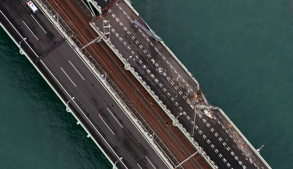 Pemandangan udara dari helikopter Jiji Press menunjukkan kerusakan jembatan yang menghubungkan ke Bandara Internasional Kansai, setelah tanker minyak bertabrakan di kota Izumisano, prefektur Osaka (5/9). (AFP Photo/Jiji Press)