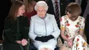 Ratu Elizabeth II berbincang dengan chief executive British Fashion Council, Caroline Rush dan Ratu Fashion, Anna Wintour (kanan) ketika menonton pagelaran London Fashion Week 2018, Selasa (20/2). (Yui Mok/Pool photo via AP)