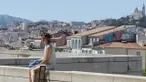 Seorang wanita duduk dengan latar belakang suasana kota di Marseille, Prancis, Minggu (3/7/2016). Marseille merupakan daerah pesisir di selatan Prancis dengan pesona keindahan alam. (Bola.com/Vitalis Yogi Trisna)