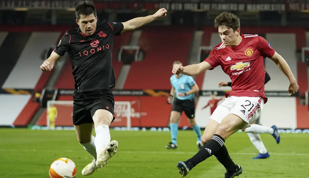 Gelandang Manchester United, Daniel James (kanan) melepaskan tendangan yang coba diblok gelandang Real Sociedad, Igor Zubeldia dalam laga leg kedua babak 32 Besar Liga Europa 2020/21 di Old Trafford Stadium, Kamis (25/2/2021). Manchester United bermain imbang 0-0 dengan Sociedad. (AP/Dave Thompson)