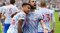 Pemain Manchester United, Jesse Lingard (kiri), dan Bruno Fernandes merayakan gol ke gawang West Ham United pada duel Premier League di London Stadium, Minggu (19/9/2021). (AP Photo/Ian Walton)