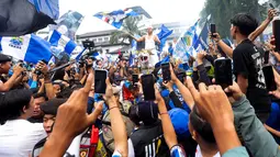 Gubernur Jawa Barat, Dedi Mulyadi, mengibarkan bendera saat merayakan Persib Bandung juara BRI Liga 1 di Gedung Sate, Bandung, Jawa Barat, Minggu, (25/5/2025). (Bola.com/M Iqbal Ichsan)