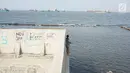 Warga memancing di perbatasan laut dan daratan di kawasan Muara Baru, Jakarta Utara, Selasa (30/7/2019). Naiknya permukaan air laut selama bertahun-tahun menyebabkan kawasan tersebut terendam banjir hingga menyatu dengan lautan. (Liputan6.com/Immanuel Antonius)