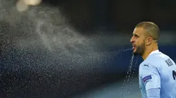 Bek Manchester City, Kyle Walker, menyemburkan air saat melawan Olympiakos pada laga Liga Champions di Stadion Etihad, Rabu (4/11/2020). Manchester City menang dengan skor 3-0. (AP/Dave Thompson)