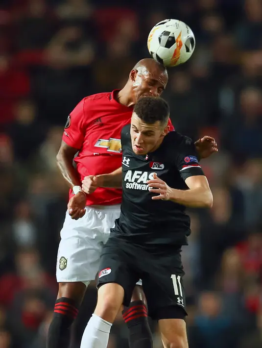 Pemain Manchester United Ashley Young (kiri) berebut bola dengan pemain AZ Alkmaar Oussama Idrissi saat pertandingan Grup L Liga Europa di Old Trafford, Manchester, Inggris, Kamis (12/12/2019). Manchester United menang 4-0. (AP Photo/Dave Thompson)