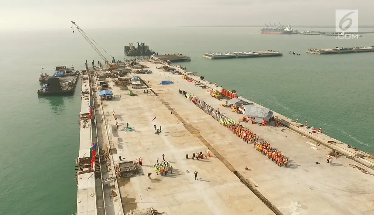 Sejumlah karyawan PT Prima Multi Terminal (PMT) mengikuti upacara bendera HUT RI ke 72 di proyek pembangunan dermaga Pelabuhan Kuala Tanjung di Kabupaten Batubara, Sumatera Utara, Kamis (17/8). (Liputan6.com/Pool