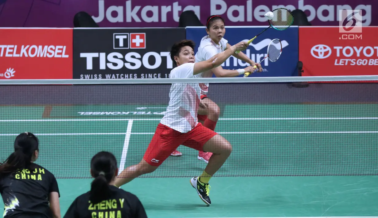 Ganda putri Indonesia, Greysia Polii/Apriyani Rahayu mengembalikan kok ke arah Tang Jinhua/Zheng Yu (China) di perempat final Bulutangkis Asian Games 2018 di Istora Kompleks GBK, Sabtu (25/8). Greysia/Apriyani unggul. (Liputan6.com/Helmi Fithriansyah)