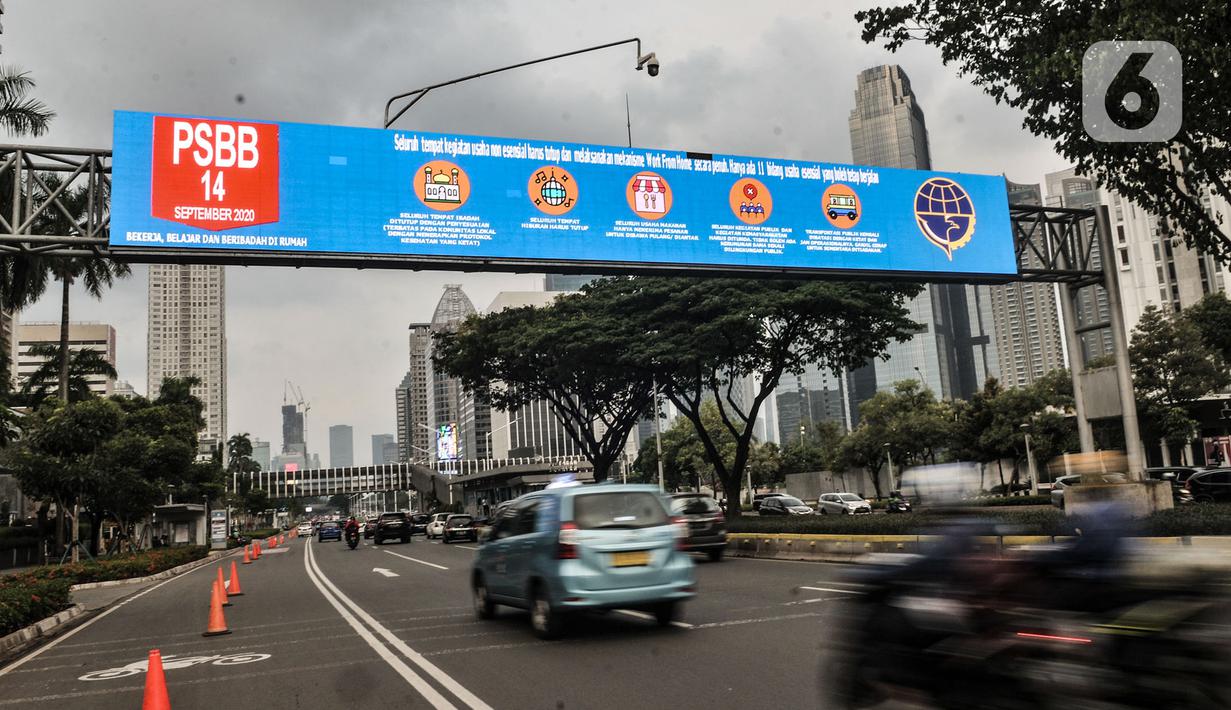 Sejumlah kendaraan melintas di bawah layar imbauan aturan PSBB di kawasan Sudirman, Jakarta, Senin (14/9/2020). Pengurangan aktivitas pekerja di perkantoran menjadi fokus utama Pemprov DKI Jakarta dalam penerapan PSBB pada 14-27 September 2020. (merdeka.com/Iqbal S. Nugroho)