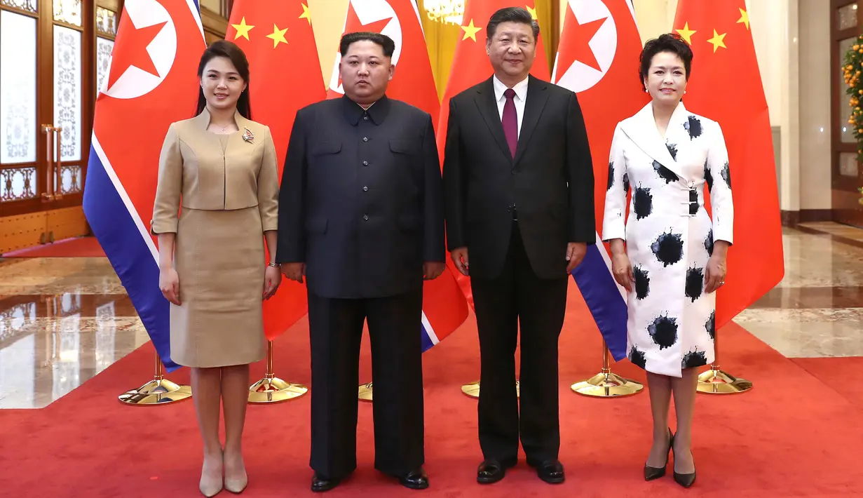 Pemimpin Korea Utara Kim Jong-un didampingi istrinya, Ri Sol-ju bertemu Presiden China Xi Jinping dan istrinya, Peng Liyuan dalam kunjungan kejutan ke Beijing, Rabu (28/3). Kunjungan tidak resmi itu berlangsung dari 25-28 Maret. (Ju Peng/Xinhua via AP)
