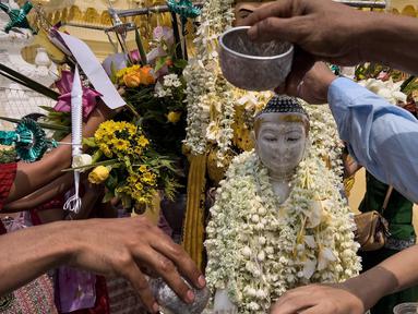Para umat menuangkan air ke patung Buddha di Pagoda Shwedagon untuk menandai Hari Ulang Tahun Buddha, yang jatuh pada Hari Bulan Purnama Kasone, di Yangon pada 11 Mei 2025. (Sai Aung MAIN/AFP)