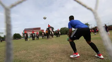 Kiper tim Ayutthaya Wittayalai School mengawasi bola selama pertandingan melawan gajah di sebuah sekolah di Provinsi Ayutthaya, Thailand, Selasa (12/6). Pertandingan digelar sebagai kampanye untuk mempromosikan Piala Dunia 2018. (AP Photo/Sakchai Lalit)