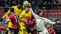 Pemain Liverpool Divock Origi (kiri atas) berebut bola udara dengan penjaga gawang AC Milan Mike Maignan (kanan) pada pertandingan sepak bola Grup B Liga Champions di Stadion San Siro, Milan, Italia, 7 Desember 2021. Liverpool menang 2-1. (MIGUEL MEDINA/AFP)
