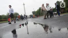 Warga berjalan-jalan di kawasan Monumen Nasional, Jakarta, Rabu (25/12/2019). Libur perayaan Natal 2019 dimanfaatkan warga Jakarta dan sekitarnya berwisata di Monumen Nasional. (Liputan6.com/Helmi Fithriansyah)
