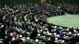 Anggota parlemen Iran mengangkat tangan saat voting RUU yang menetapkan pasukan militer Amerika Serikat sebagai teroris, Teheran, Selasa (7/1/2020). Mosi tersebut telah ditandatangani oleh anggota dewan pimpinan parlemen dan Komisi Integrasi Anggaran. (AP Photo/Vahid Salemi)